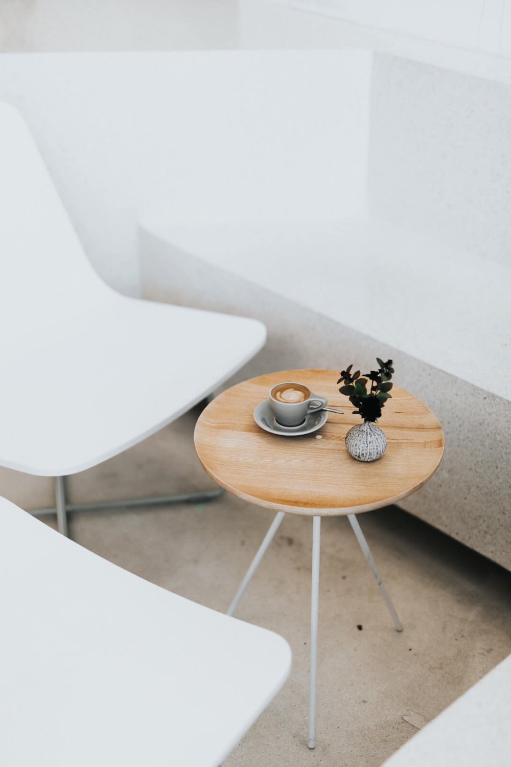 Coffee and a small vase on a round wooden table